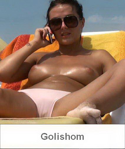 Девушка загорает топлес на пляже