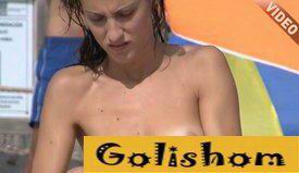 Симпатичная девушка натирается маслом на пляже видео